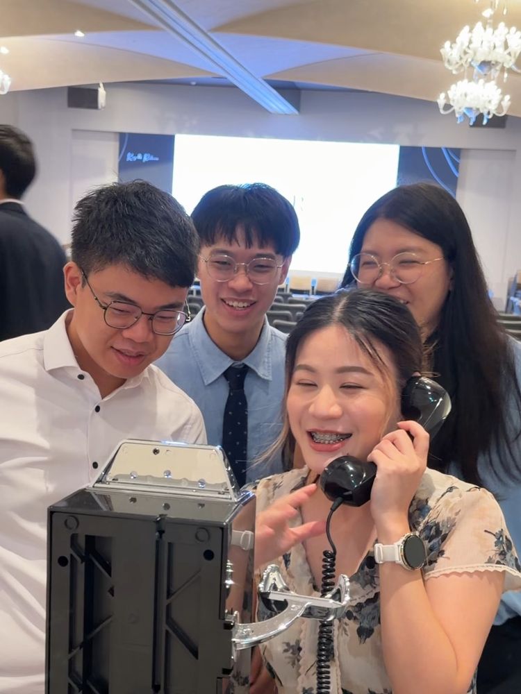 一群賓客圍在電話旁，笑著輪流留言